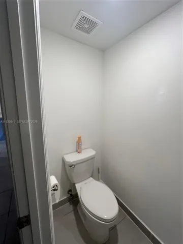 a white toilet sitting next to a shower