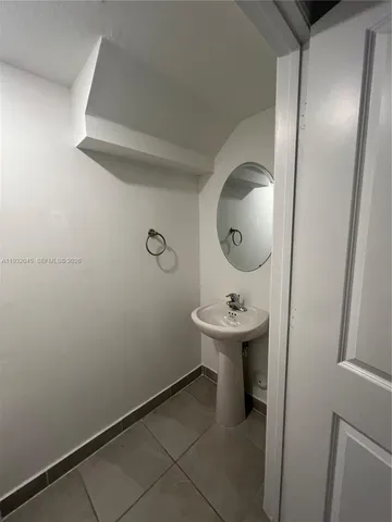 a bathroom with a sink and mirror with toilet