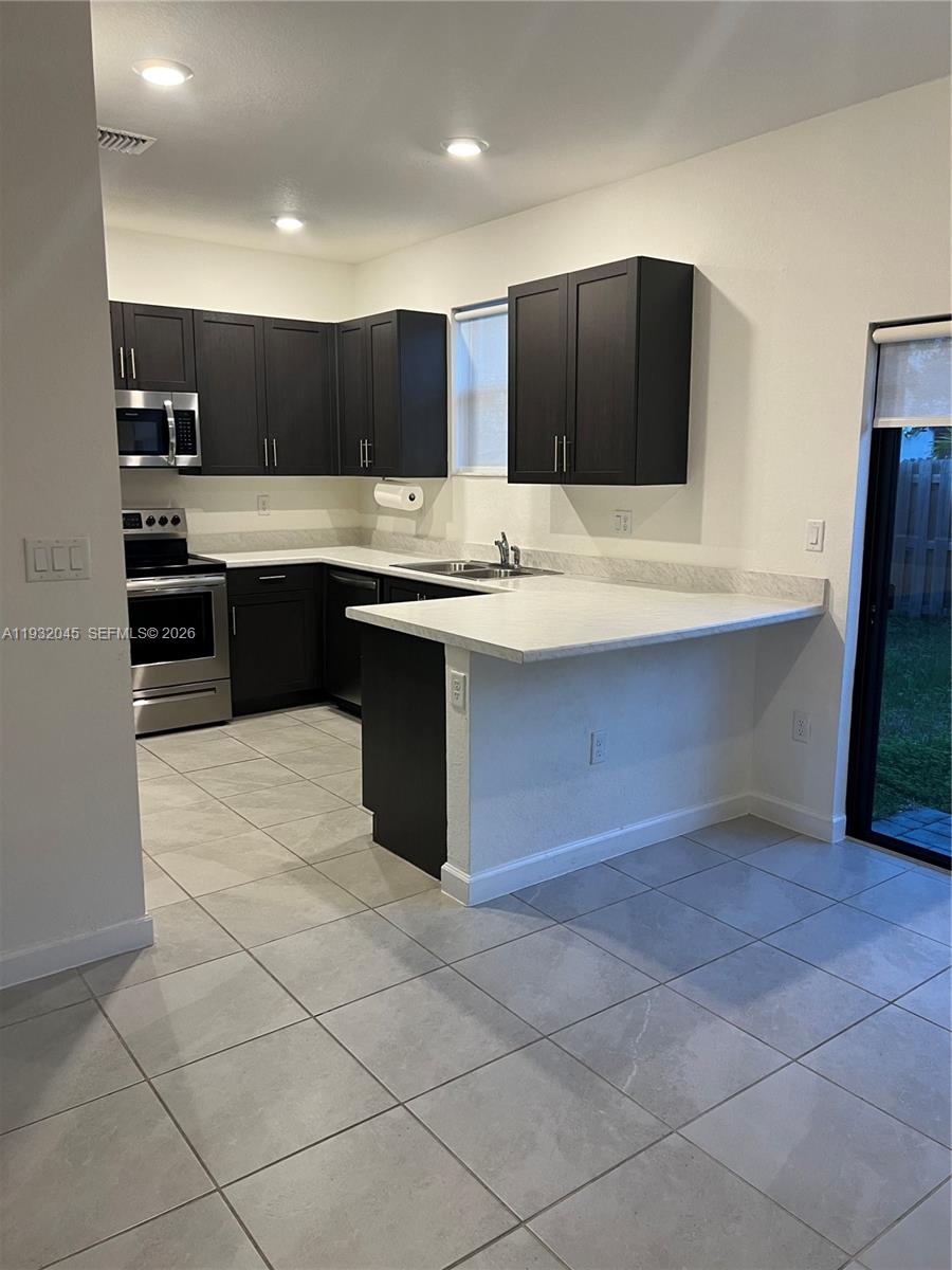 13387 Southwest 287th Terrace Homestead, FL 33033 - Photo 48 of 50 a kitchen with a sink and cabinets