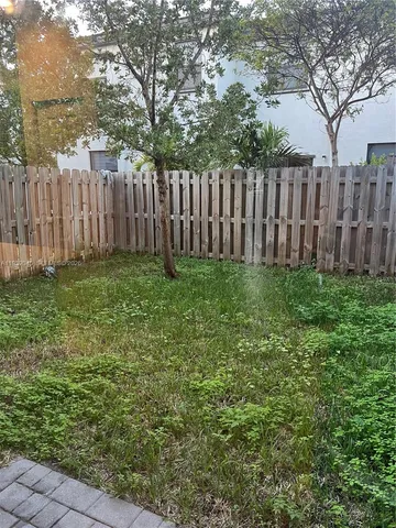 a view of a backyard with wooden fence