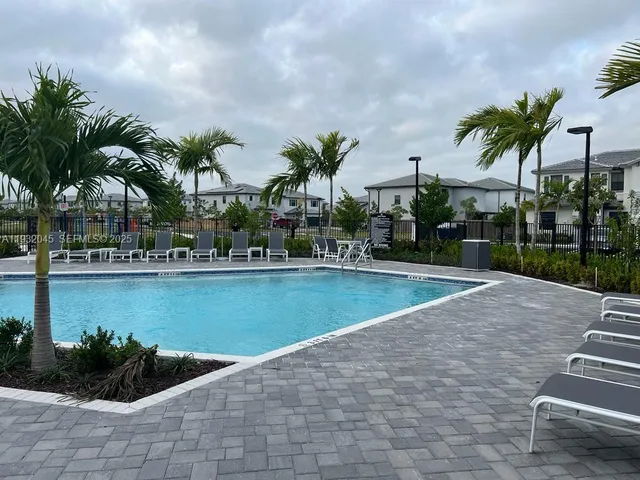 a view of swimming pool with outdoor seating and plants