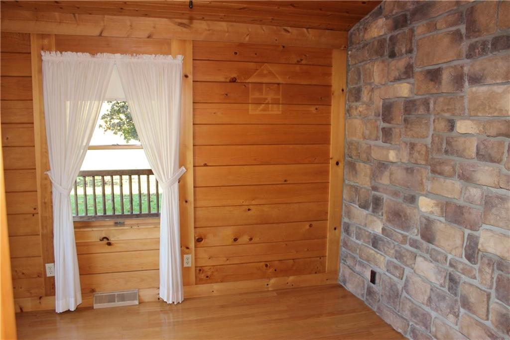 190 Leslie Road Valencia, PA 16059 - Photo 19 of 25 Main floor Bedroom #2 features vaulted ceiling, oak flooring, two windows, a gorgeous stone feature wall and a full, private bathroom.