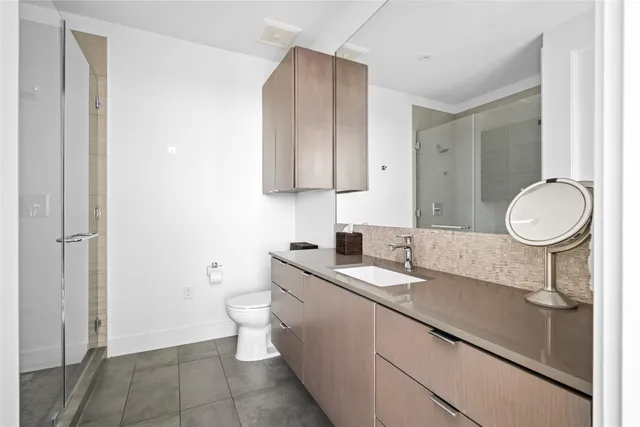 a bathroom with a sink a toilet and a mirror