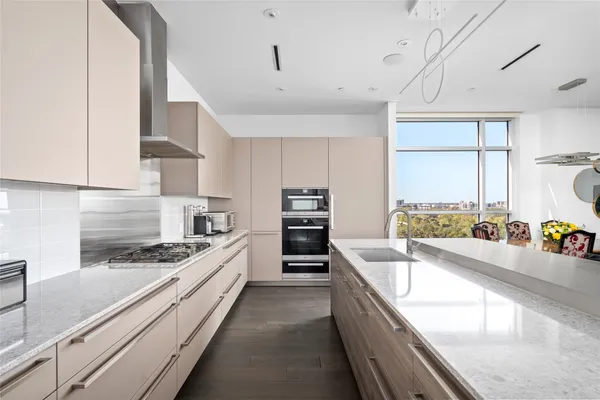 a large kitchen with stainless steel appliances granite countertop a lot of counter space and wooden floors