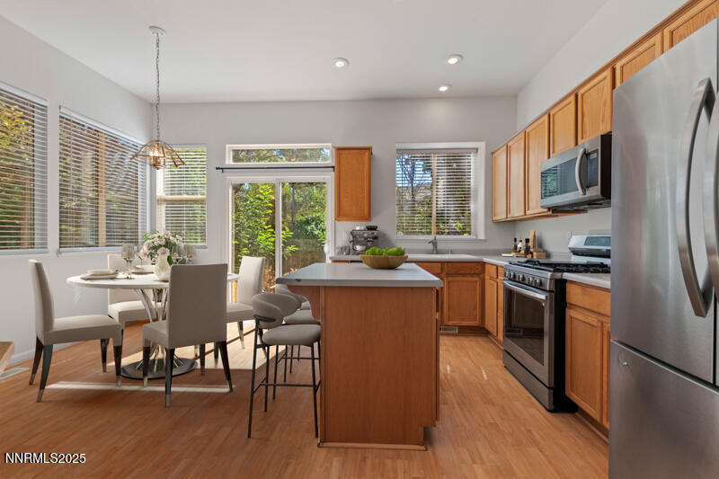 5540 Daybreak Drive Reno, NV 89523 - Photo 11 of 22 a kitchen with stainless steel appliances granite countertop a stove a refrigerator a kitchen island a table and chairs