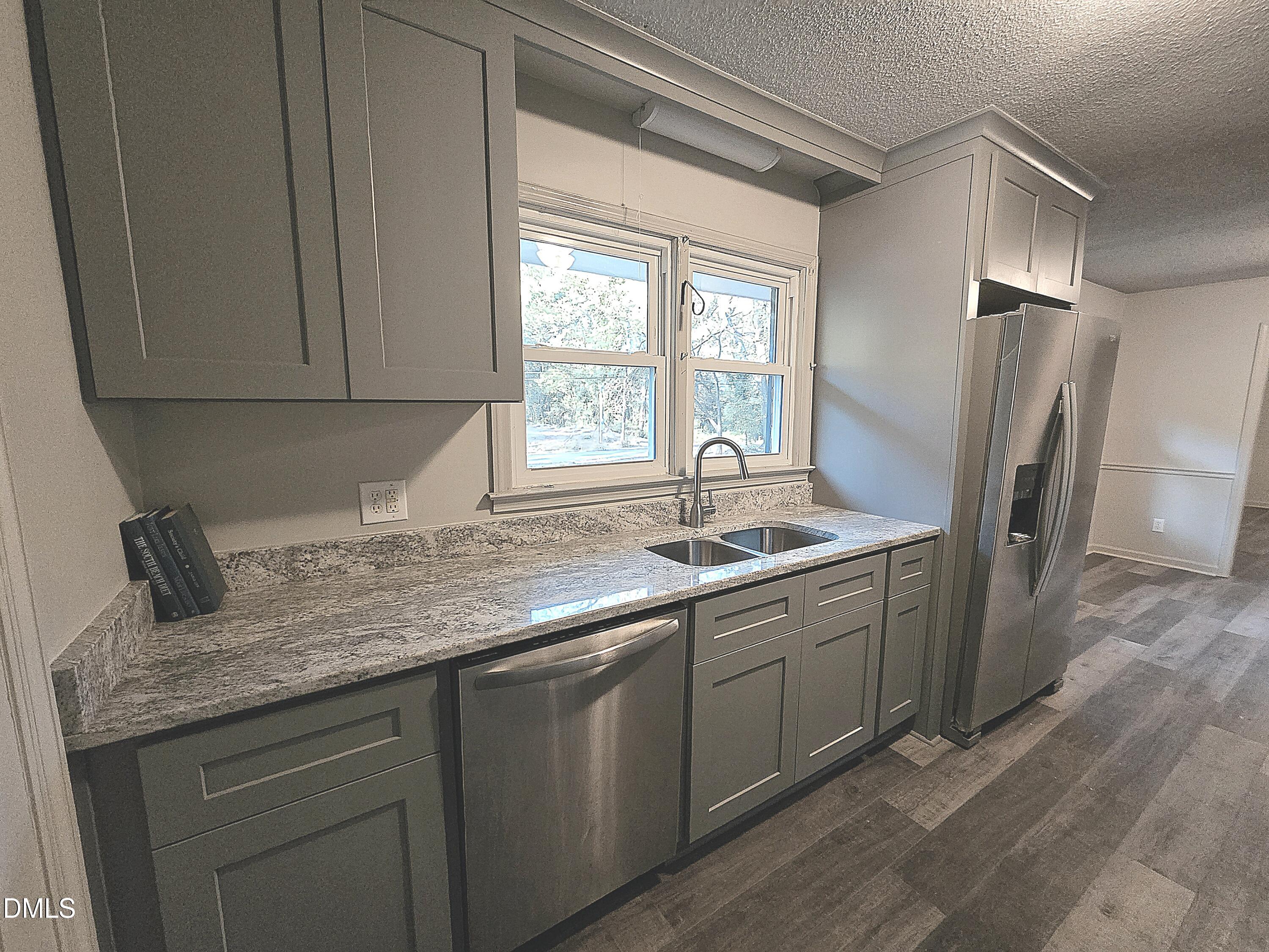 807 Grovemont Road Raleigh, NC 27603 - Photo 9 of 22 a kitchen with stainless steel appliances granite countertop a sink stove and refrigerator