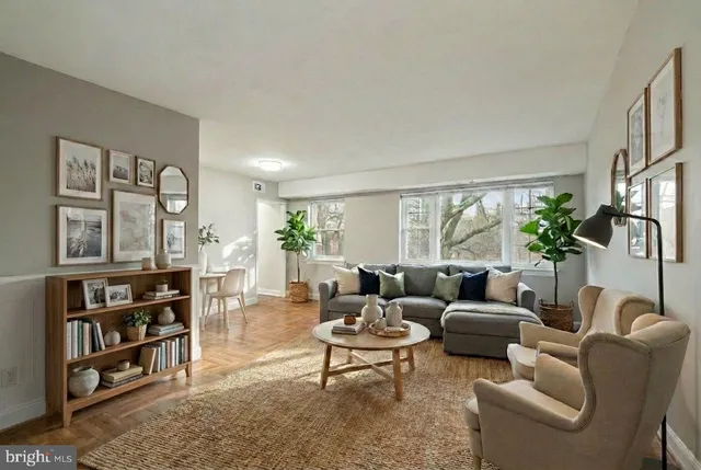 a living room with furniture a bookshelf and a large window