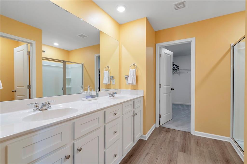 660 Groover Street Ball Ground, GA 30107 - Photo 26 of 53 a bathroom with a double vanity sink and mirror with shower