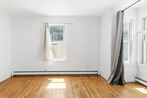 a view of a room with wooden floor and a window