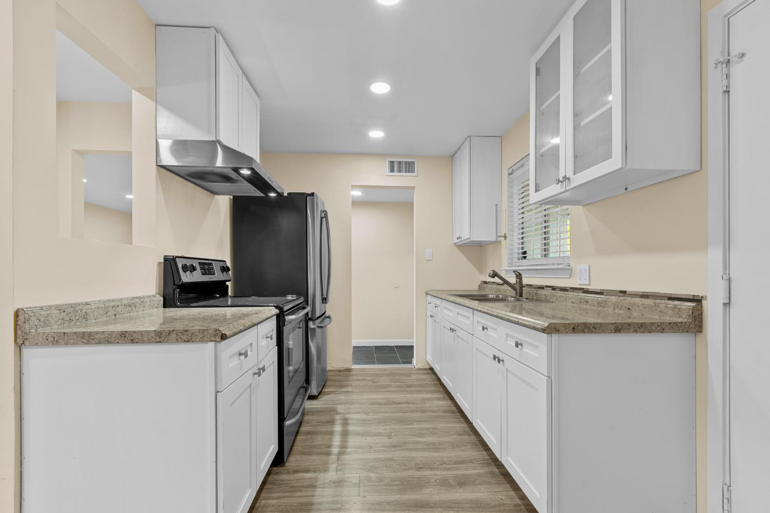 2121 Aaron Way Sacramento, CA 95822 - Photo 11 of 47 a kitchen with granite countertop a sink stove and refrigerator