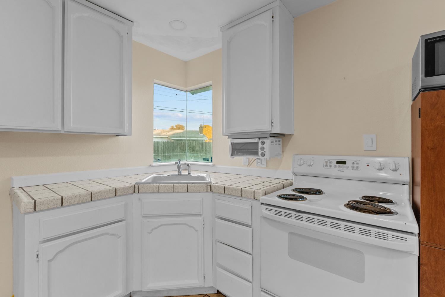 2121 Aaron Way Sacramento, CA 95822 - Photo 27 of 47 a kitchen with white cabinets sink and white appliances