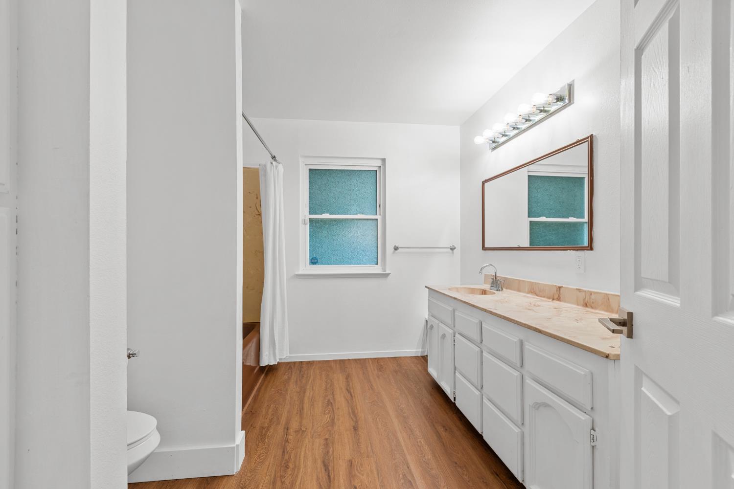 2121 Aaron Way Sacramento, CA 95822 - Photo 28 of 47 a bathroom with a sink a mirror and a toilet