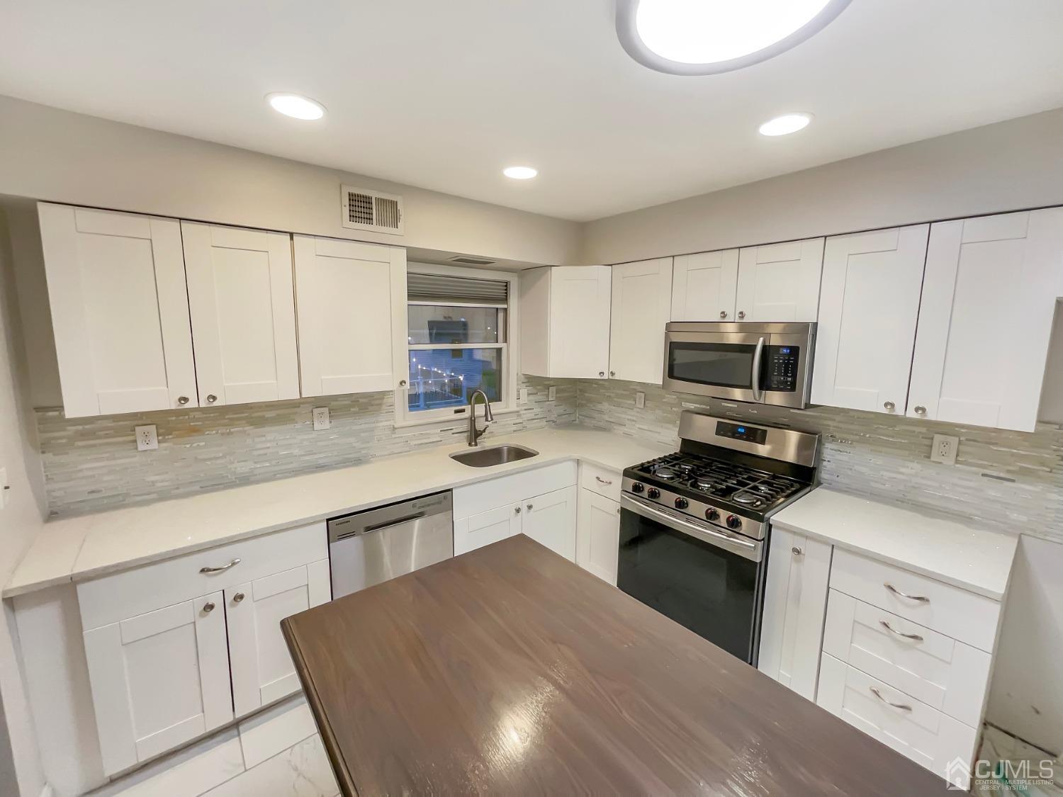 6 Ericson Avenue Helmetta, NJ 08828 - Photo 2 of 15 a kitchen with granite countertop white cabinets white stainless steel appliances and sink