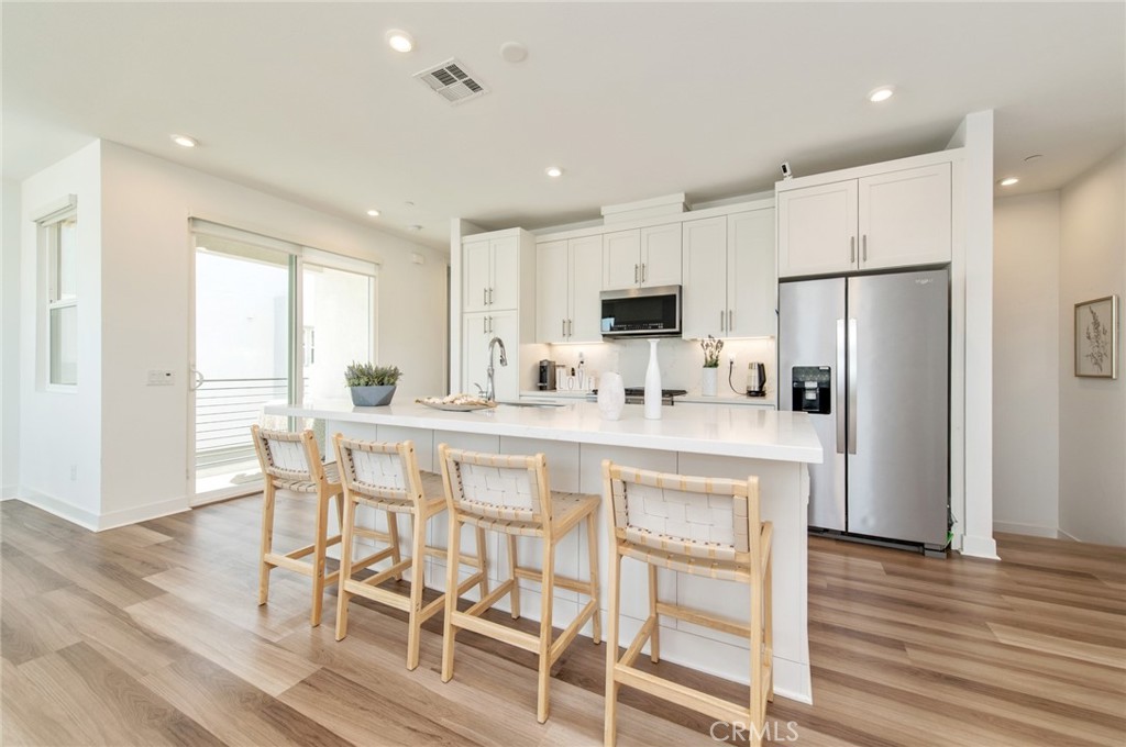 a kitchen with kitchen island white cabinets and stainless steel appliances