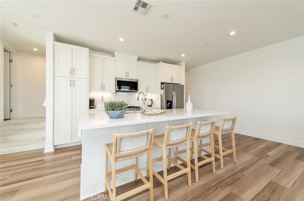 1515 West Bushell Street Anaheim, CA 92805 - Photo 3 of 22 a kitchen with white cabinets and stainless steel appliances