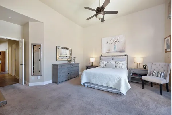 a spacious bedroom with a large bed and a chandelier
