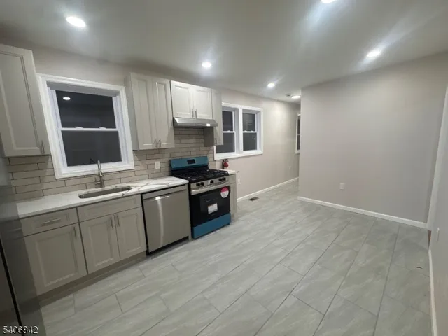 a kitchen with stainless steel appliances granite countertop a stove a sink and a refrigerator