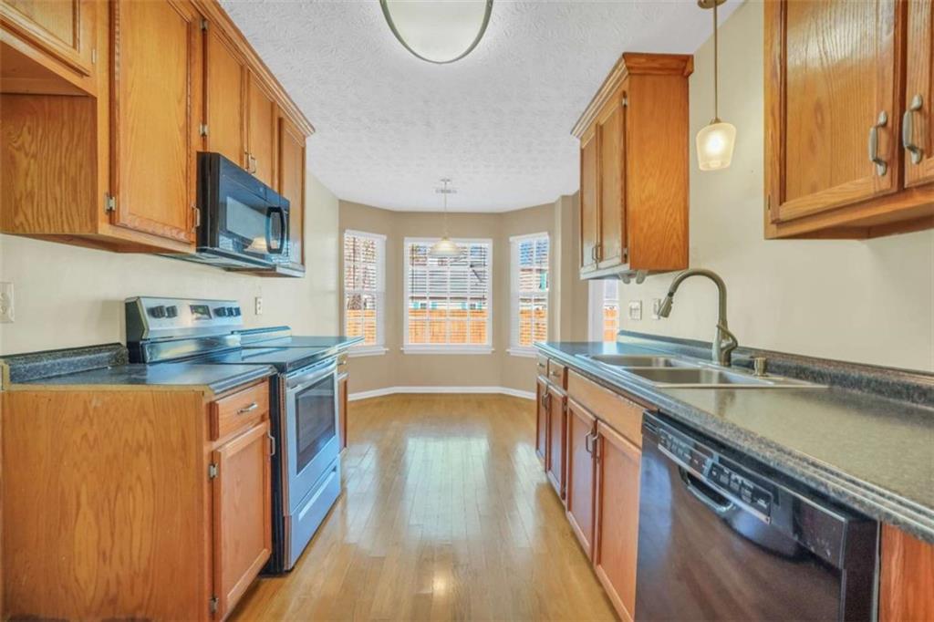130 Deep Step Road Covington, GA 30014 - Photo 11 of 35 a kitchen with stainless steel appliances granite countertop a sink a stove and a wooden floors