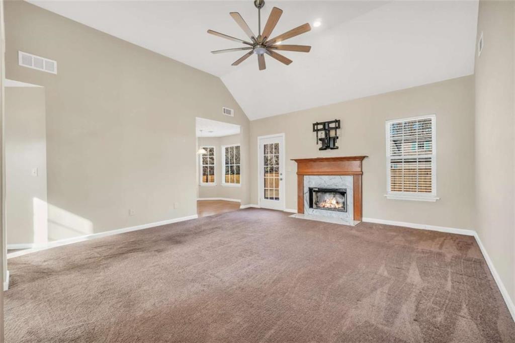 130 Deep Step Road Covington, GA 30014 - Photo 17 of 35 a view of a livingroom with a fireplace a ceiling fan and windows