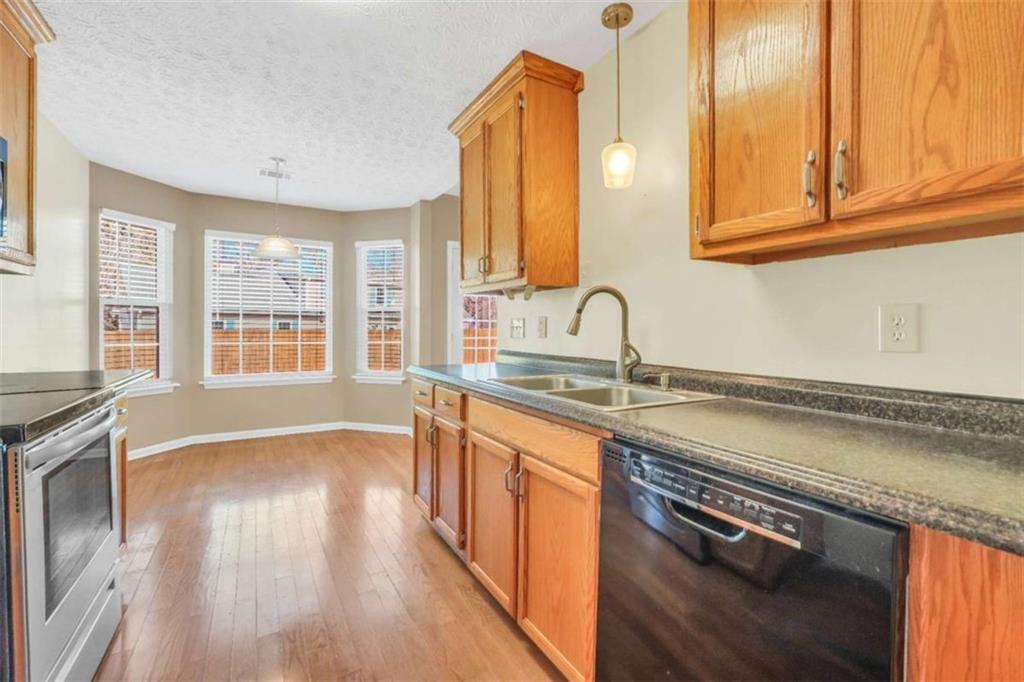 130 Deep Step Road Covington, GA 30014 - Photo 2 of 35 a kitchen with stainless steel appliances granite countertop a sink a stove cabinets and wooden floor