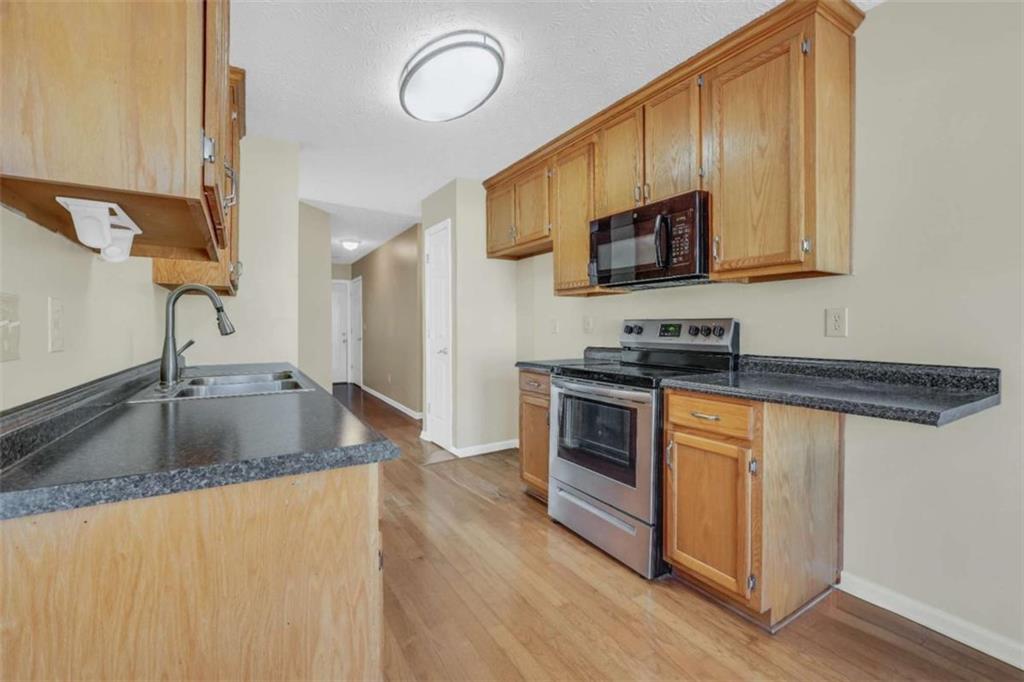 130 Deep Step Road Covington, GA 30014 - Photo 34 of 35 a kitchen with stainless steel appliances granite countertop a sink stove and refrigerator