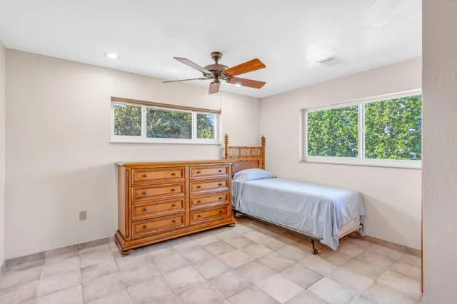 a bed sitting in a spacious bedroom next to a window