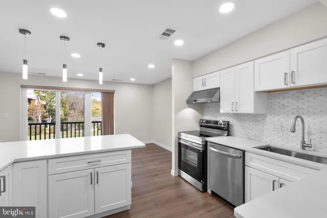 a kitchen with stainless steel appliances granite countertop a sink and a stove