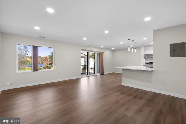 an open space with kitchen view and wooden floor
