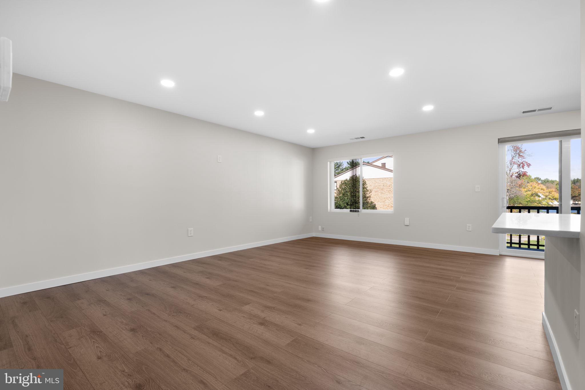 10053 Windstream Drive, Unit 3 Columbia, MD 21044 - Photo 4 of 30 an empty room with wooden floor and windows