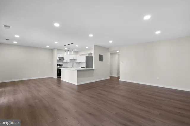 a view of kitchen with kitchen island wooden floor center island and stainless steel appliances with wooden floor