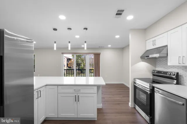 a kitchen with white cabinets and stainless steel appliances