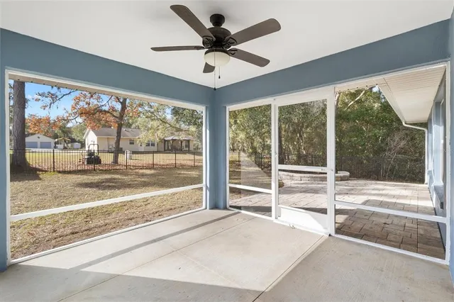 a living room with a large window and a ceiling fan