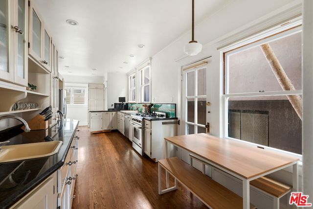 a large kitchen with stainless steel appliances a lot of counter space and wooden floor