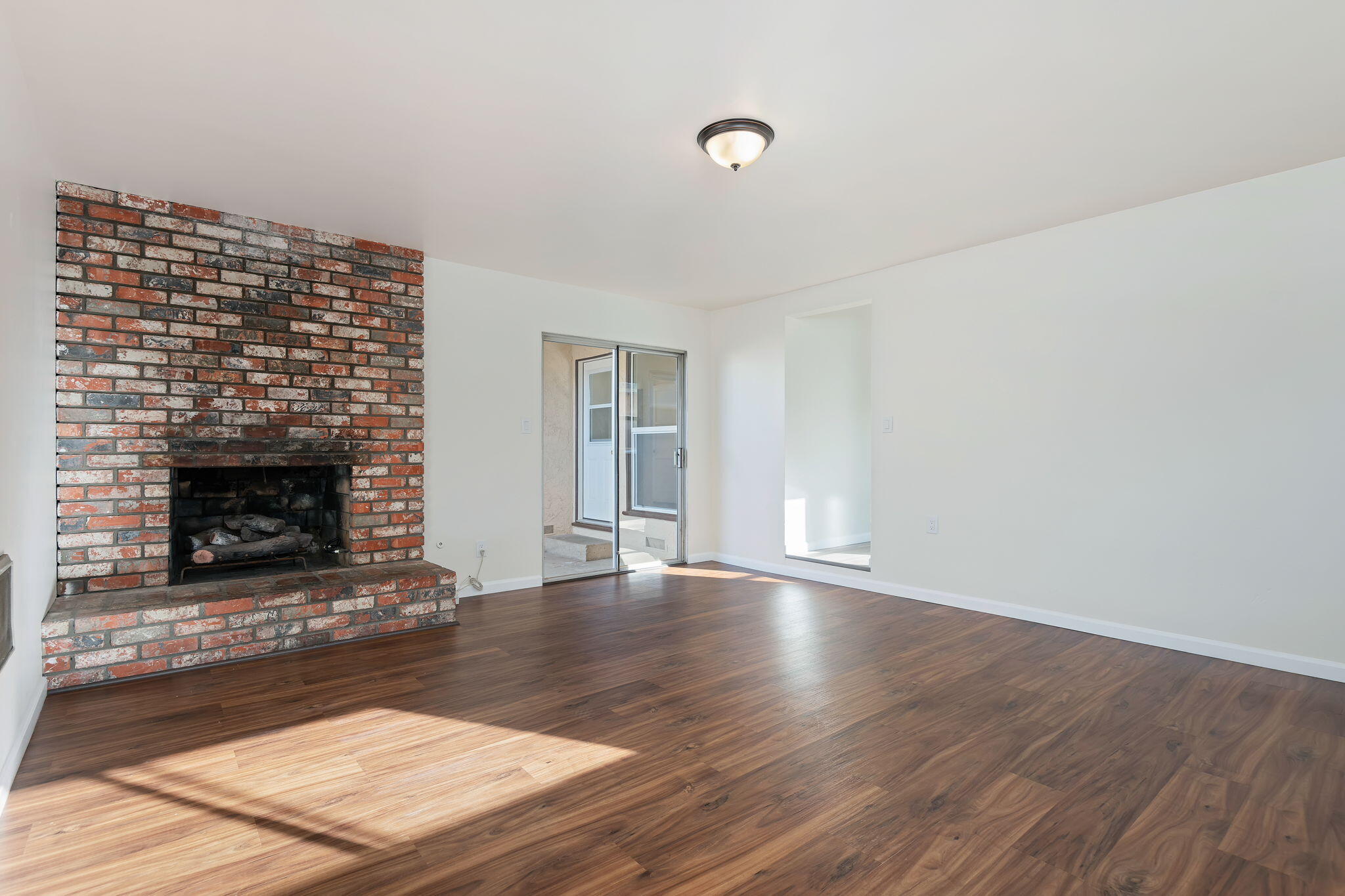 325 North J Street Oxnard, CA 93030 - Photo 15 of 25 a view of an empty room with wooden floor fireplace and a window