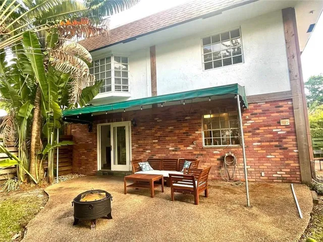 a view of a patio with table and chairs and wooden fence