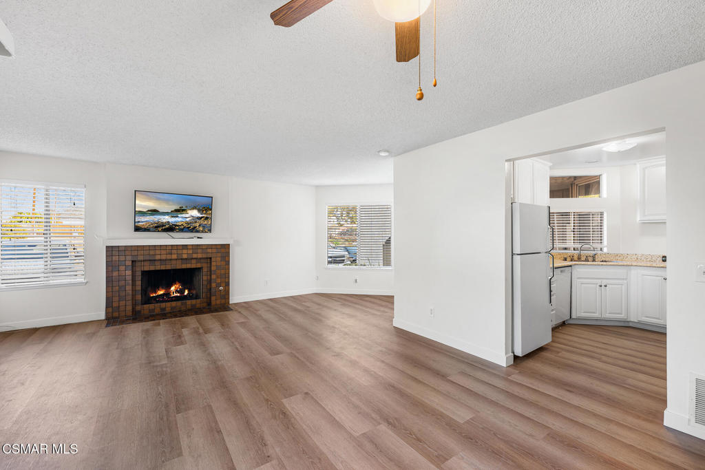 1748 Sinaloa Road, Unit 158 Simi Valley, CA 93065 - Photo 7 of 21 an empty room with windows fireplace and wooden floor