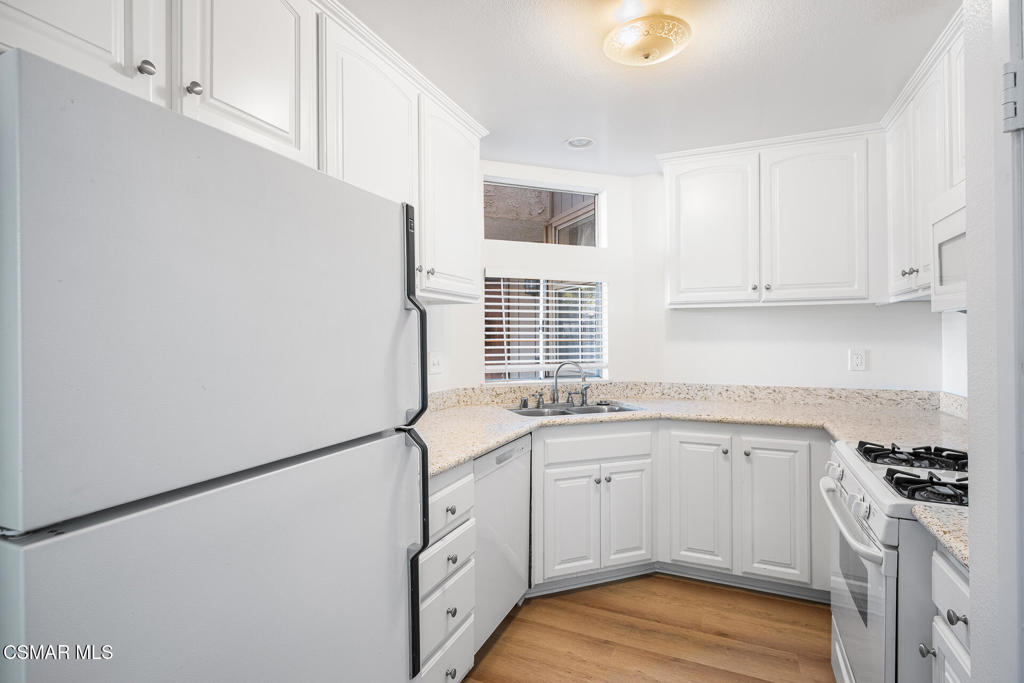 1748 Sinaloa Road, Unit 158 Simi Valley, CA 93065 - Photo 9 of 21 a kitchen with granite countertop a sink cabinets stainless steel appliances and a window