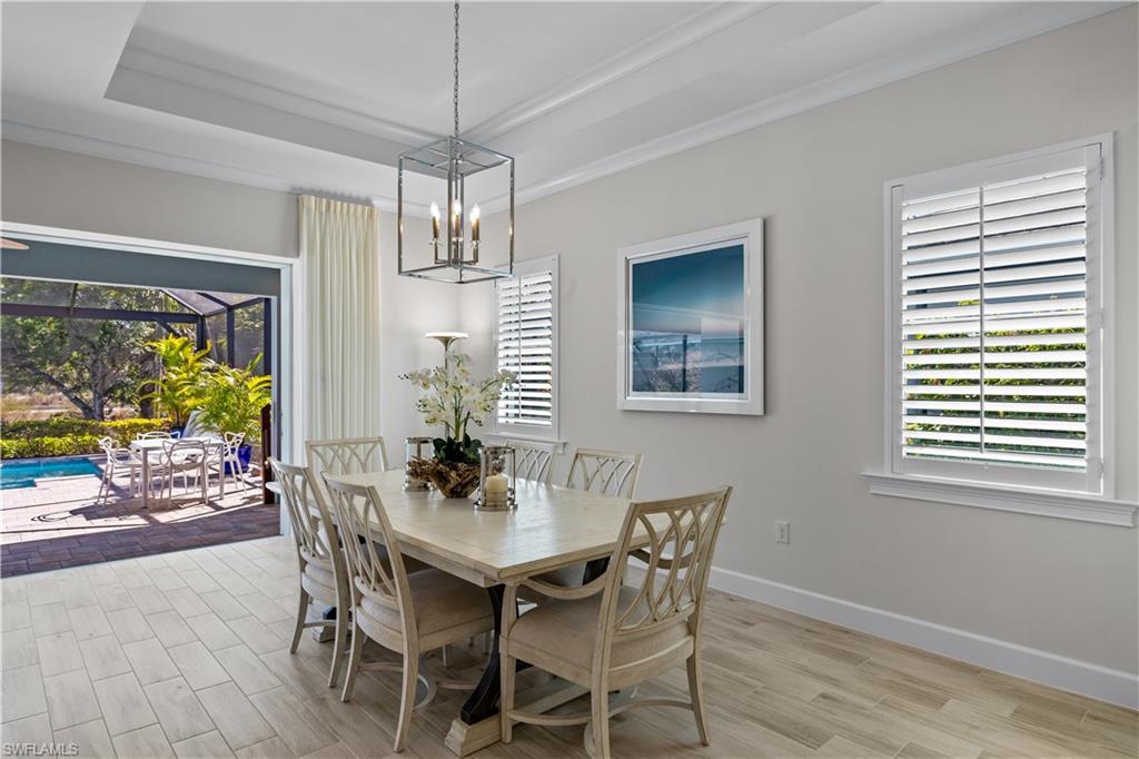 6359 Antigua Way Naples, FL 34113 - Photo 13 of 48 a dining room with furniture a window and a chandelier