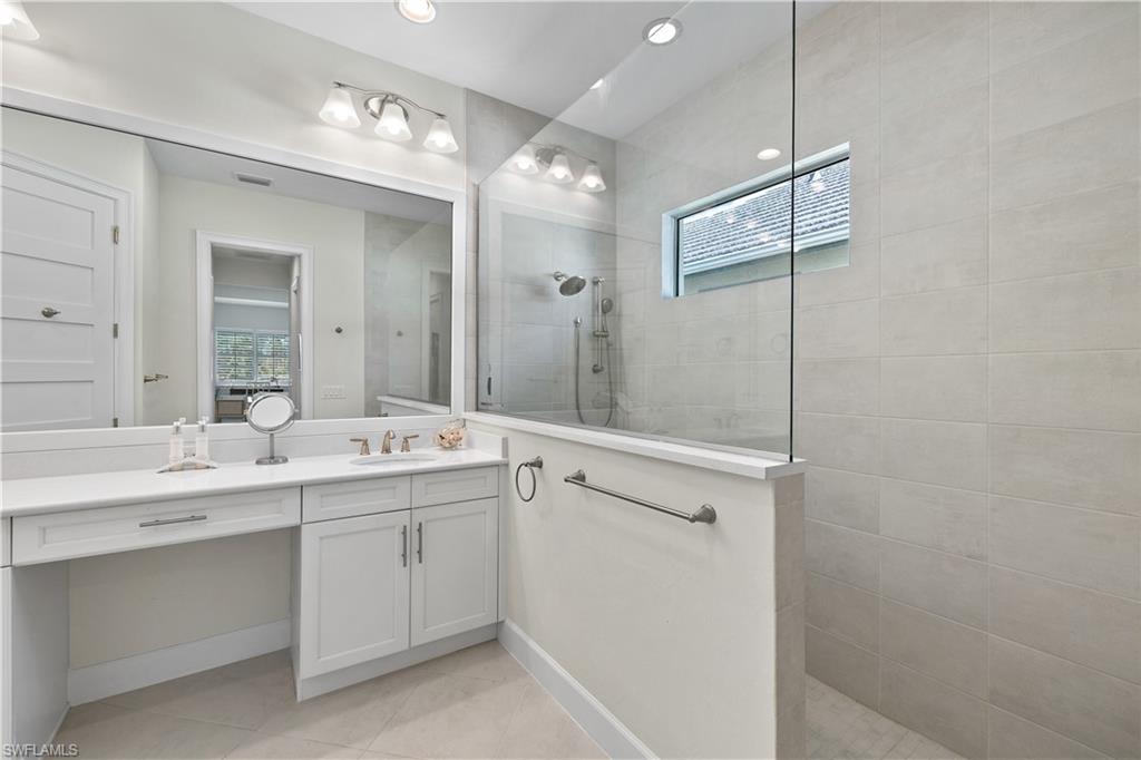 6359 Antigua Way Naples, FL 34113 - Photo 18 of 48 a view of a double vanity sink mirror and cabinets