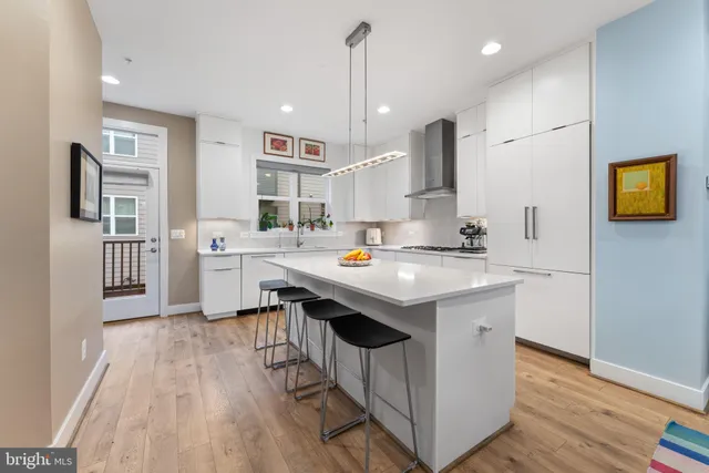 a kitchen with stainless steel appliances kitchen island a sink refrigerator and microwave