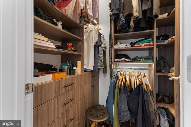 a view of walk in closet with clothes and shoes