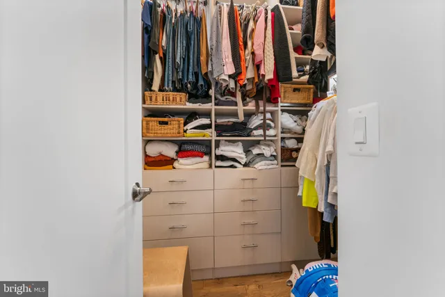 a view of walk in closet with clothes and shoes
