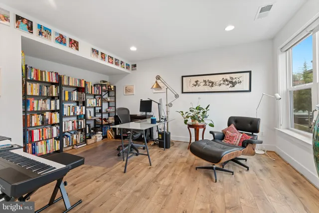 a living room with furniture and a book shelf