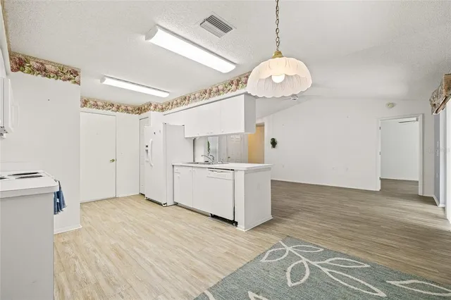 a view of a kitchen with a sink dishwasher and a fireplace with wooden floor