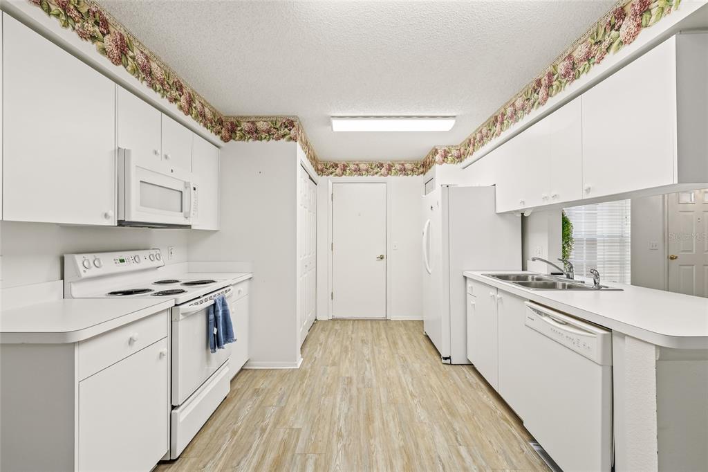 7343 Willowbrook Drive Spring Hill, FL 34606 - Photo 18 of 47 a kitchen with a stove a sink and a refrigerator