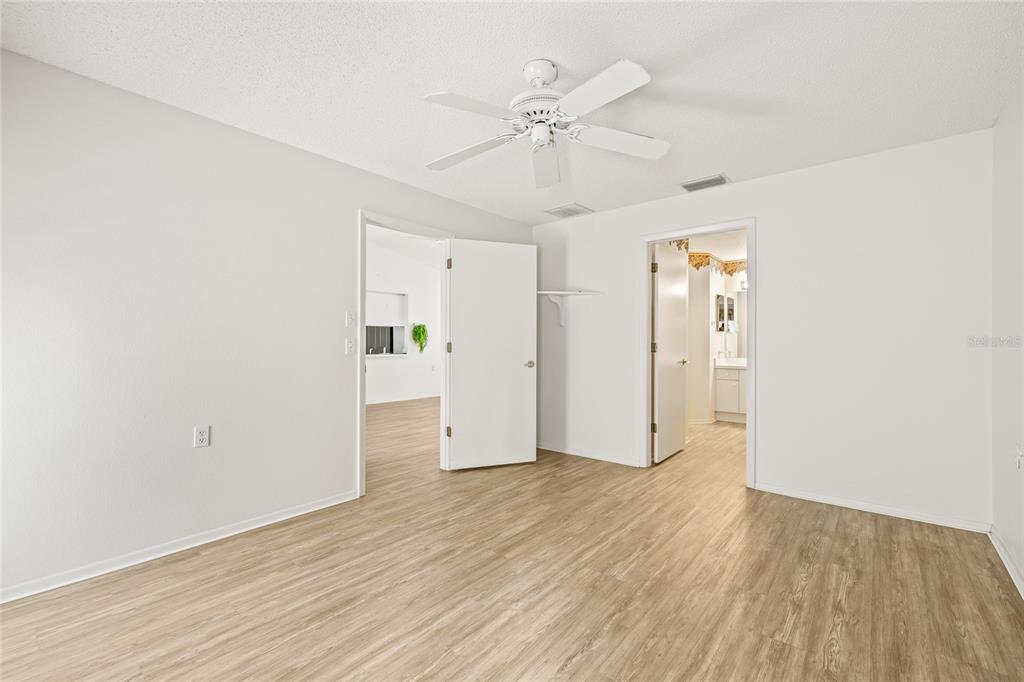 7343 Willowbrook Drive Spring Hill, FL 34606 - Photo 22 of 47 an empty room with wooden floor fan and windows