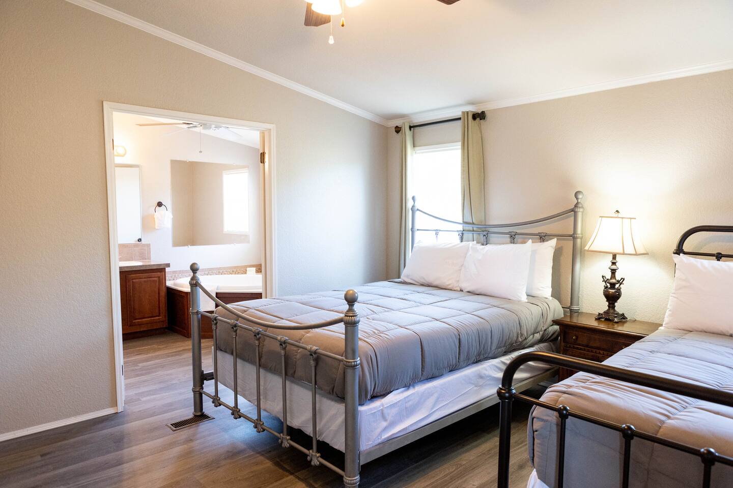 1901 Harmon Hills Road Dripping Springs, TX 78620 - Photo 24 of 27 Bedroom featuring dark wood-style flooring, crown molding, ensuite bathroom, a ceiling fan, and vaulted ceiling
