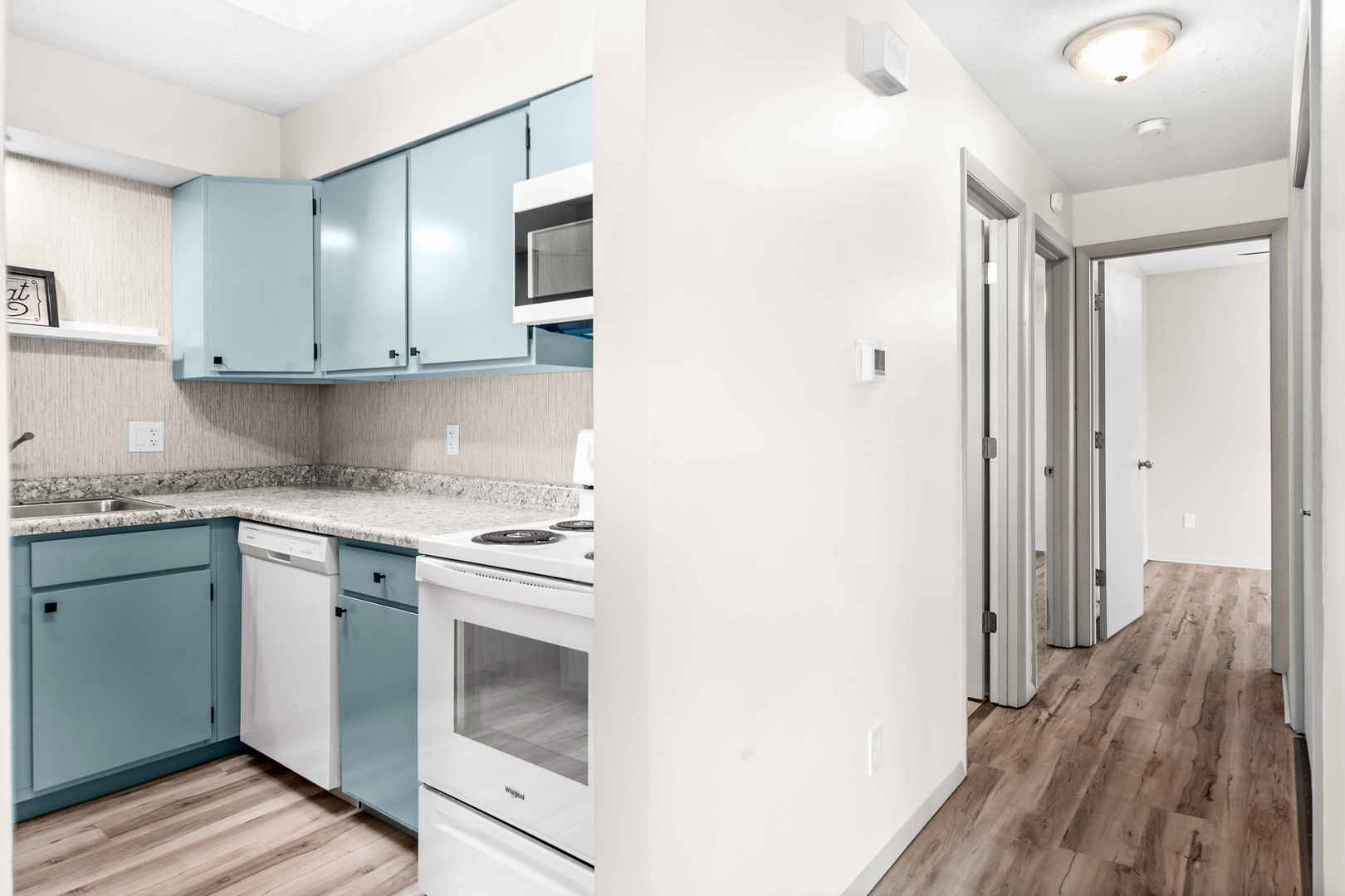903 North Linden Street, Unit 17 Normal, IL 61761 - Photo 12 of 26 a kitchen with granite countertop cabinets stainless steel appliances and wooden floor