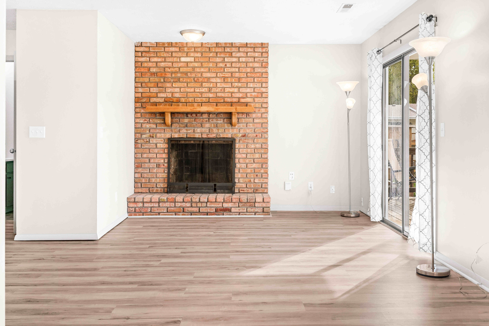 903 North Linden Street, Unit 17 Normal, IL 61761 - Photo 7 of 26 a view of an empty room with wooden floor and a fireplace