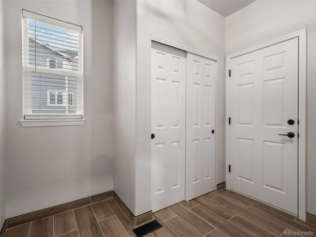 a view of an empty room with wooden cabinet and a kitchen